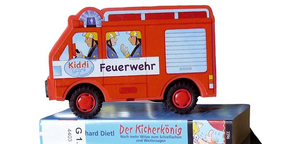 Feuerwehrauto (Spielzeug) auf Kinderbuch stehend