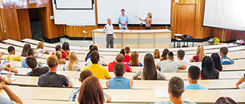 Blick in einen Hörsaal mit Studierenden und Professor